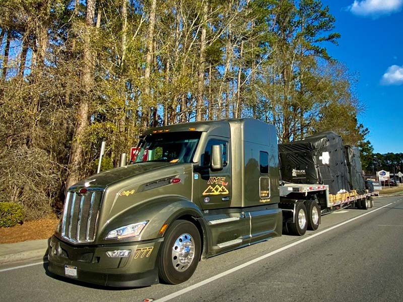 IMS West truck with tarped freight on the road